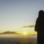 Woman facing sunrise