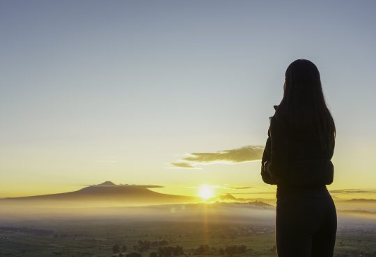 Woman facing sunrise