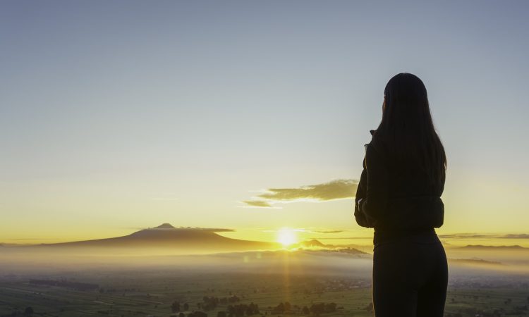Woman facing sunrise