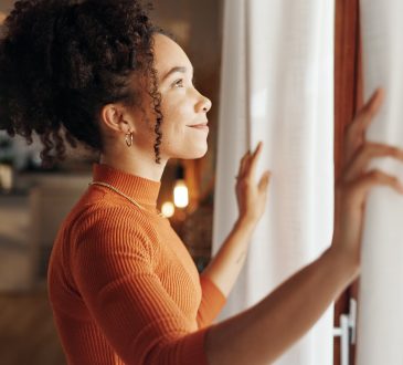 Curtains, happy woman and thinking of future in home, planning and reflection of mindset with view. Window, smile and African girl with vision, ideas and dream for morning inspiration in living room