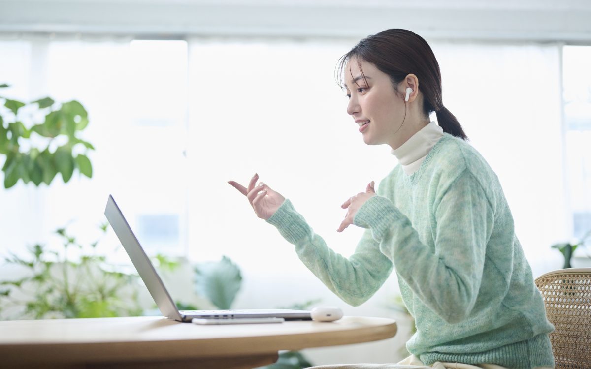 A woman in her 20s having an online meeting in her living room