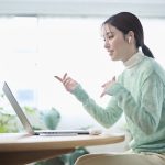 A woman in her 20s having an online meeting in her living room