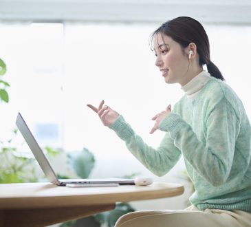 A woman in her 20s having an online meeting in her living room
