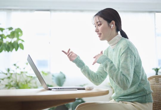 A woman in her 20s having an online meeting in her living room