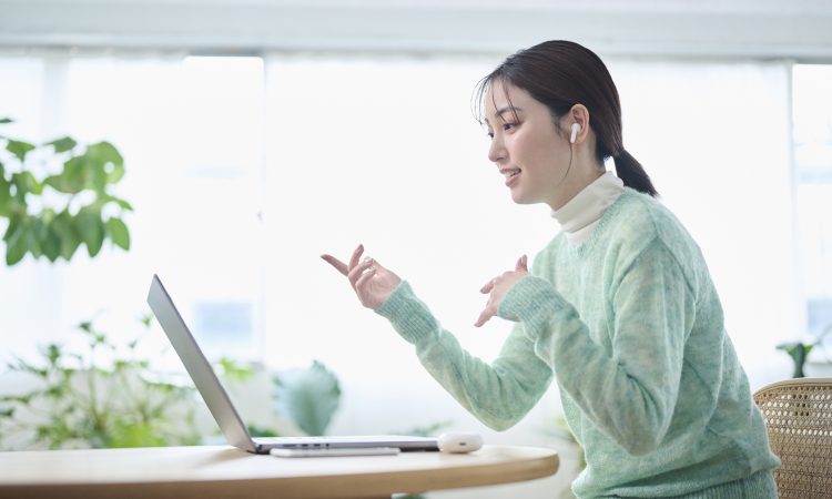 A woman in her 20s having an online meeting in her living room