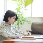 Young Japanese woman studying online in the living room