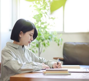Young Japanese woman studying online in the living room