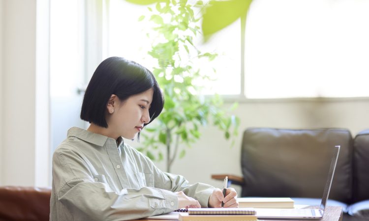 Young Japanese woman studying online in the living room