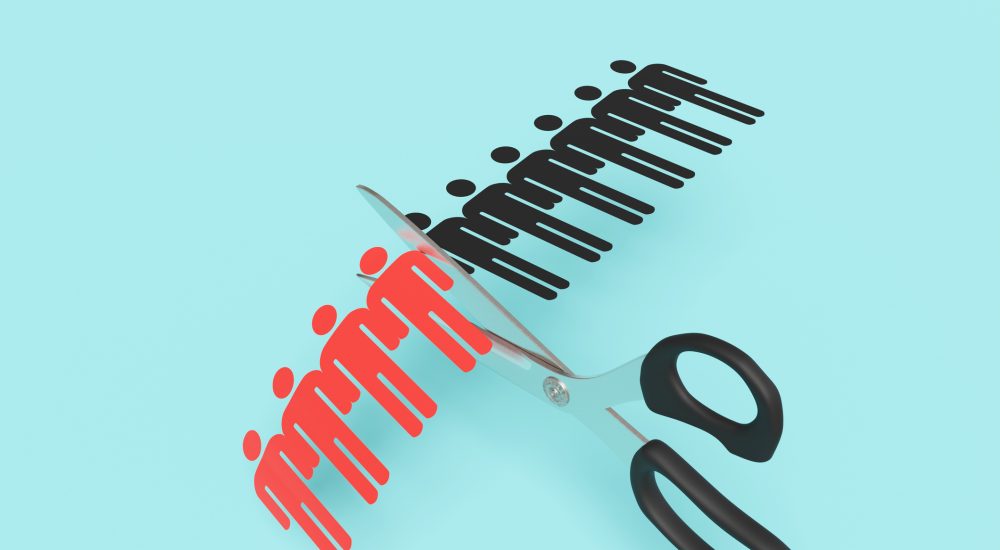 Scissors cutting a paper craft of a row of human shaped outline on blue background. Illustration of the concept of layoff and downsizing of staff