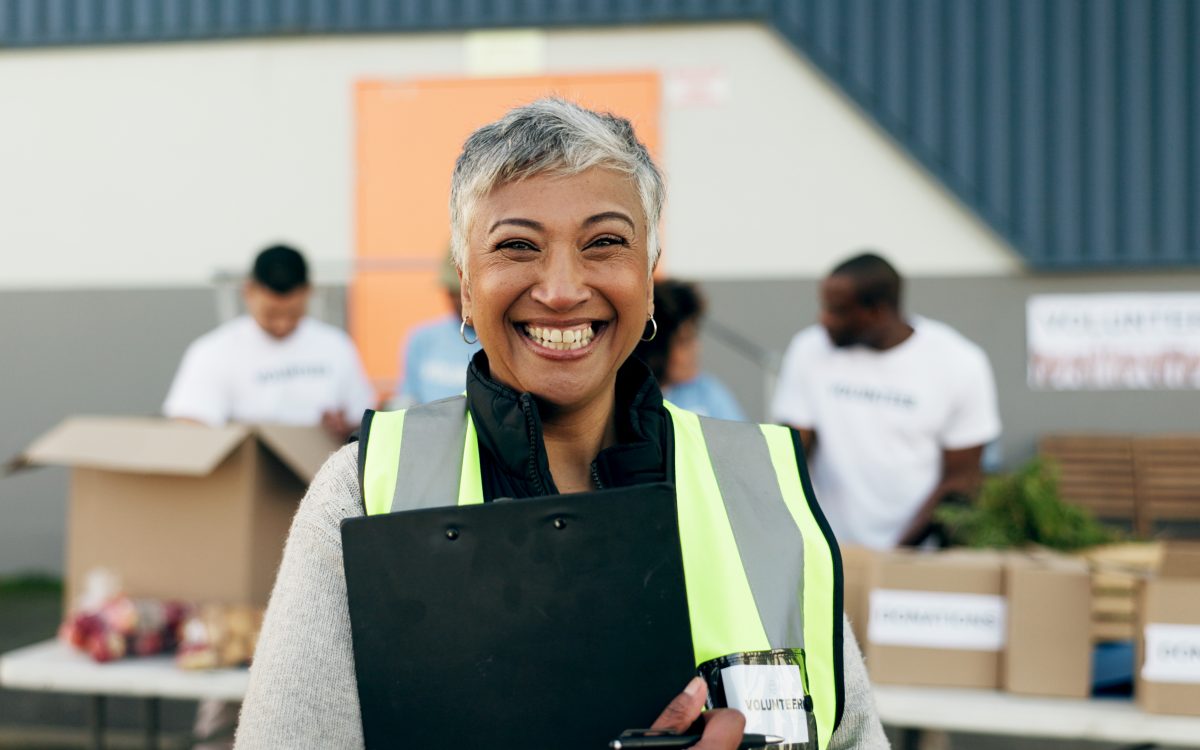 Woman, clipboard and manager in charity, volunteer and organizer for outreach program, smile and portrait. Happy senior person, non profit and support in social responsibility for NGO foundation