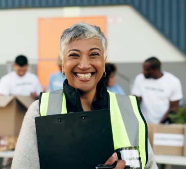 Woman, clipboard and manager in charity, volunteer and organizer for outreach program, smile and portrait. Happy senior person, non profit and support in social responsibility for NGO foundation