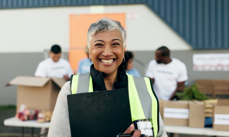 Woman, clipboard and manager in charity, volunteer and organizer for outreach program, smile and portrait. Happy senior person, non profit and support in social responsibility for NGO foundation