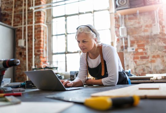 Confident senior woman working in workshop
