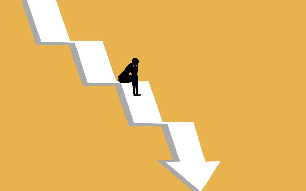 businessman sat stressed on the crisis arrow