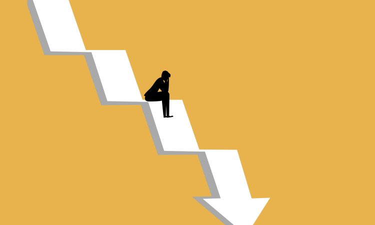 businessman sat stressed on the crisis arrow